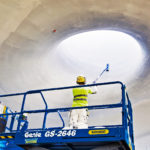 2. Sen p&auml;&auml;lle ruiskutetaan Rockfon Mono -pinnoite, joka absorboi &auml;&auml;nt&auml; ja on lis&auml;ksi energiatehokas. Katto saa lopullisen ulkon&auml;k&ouml;ns&auml; pohjat&ouml;iden p&auml;&auml;lle teht&auml;v&auml;st&auml; tasaisesta ruiskupinnoituksesta.